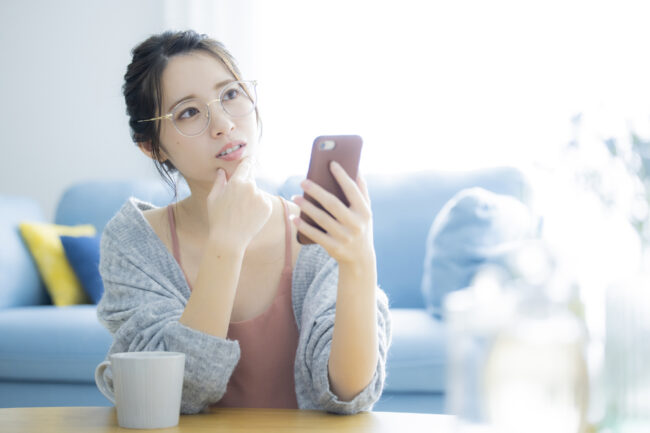 女性　スマホ　悩む