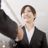 握手をしているスーツ姿を着た女性